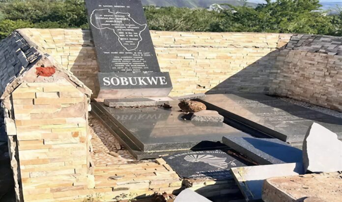 Vandalised grave of South African anti-apartheid revolutionary Robert Mangaliso Sobukwe in Robert Sobukwe Town, showing broken slabs and damaged tombstone.