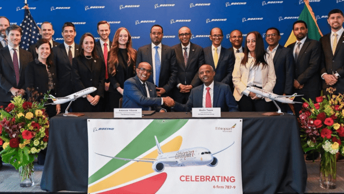 Ethiopian Airlines Group chief executive Mesfin Tasew shakes hands with Boeing Commercial Airplanes executive Anbessie Yitbarek during the signing ceremony for six additional Boeing 787-9 Dreamliners, surrounded by Ethiopian Airlines and Boeing officials.