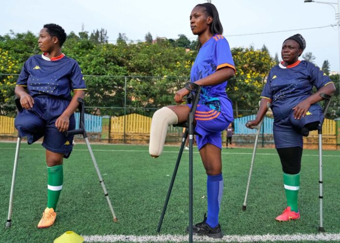 Women amputee footballers train with crutches on a pitch in Kigali, Rwanda.