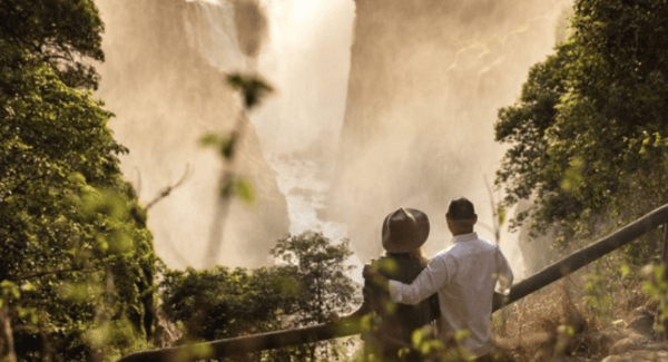 A couple views the Smoke that Thunders the Victoria Falls, in Zimbabwe. Image courtesy of Wilderness