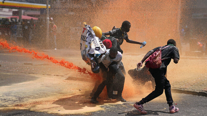 Protesters scatter as Kenya police spray water canon at them during a protest over proposed tax hikes in a finance bill in downtown Nairobi, Kenya Tuesday, June. 25, 2024.- Image Credit: [AFP]