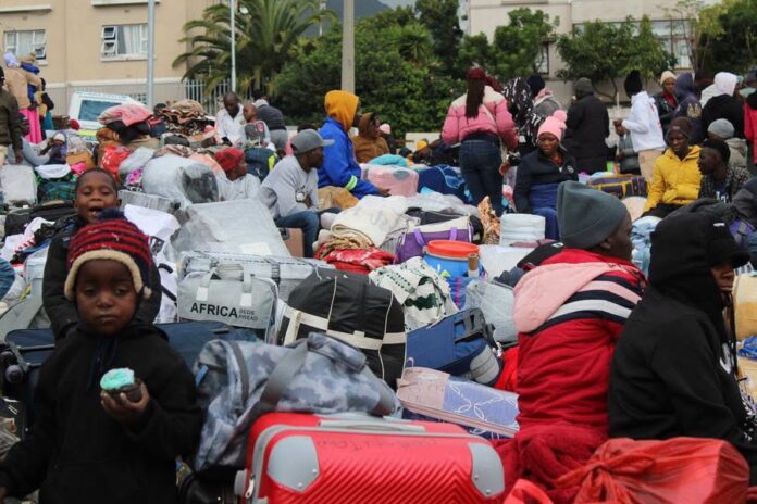 A group of Zimbabwean returnees carrying their belongings as they await repatriation back to Zimbabwe after fleeing violence in South Africa.