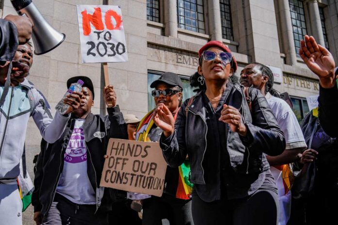 UK-based Zimbabweans gather outside the Zimbabwe Embassy in London, United Kingdom, on April 18, 2026, to protest the Constitution of Zimbabwe Amendment (No. 3) Bill. The bill is reported to potentially extend President Mnangagwa's rule until 2030 and change the process of electing the president. (Photo by Maynard Manyowa/News Images/NurPhoto) (Photo by News Images / NurPhoto via AFP) UK-based Zimbabweans gather outside the Zimbabwe Embassy in London, United Kingdom, on April 18, 2026, to protest the Constitution of Zimbabwe Amendment (No. 3) Bill. The bill is reported to potentially extend President Mnangagwa's rule until 2030 and change the process of electing the president. (Photo by Maynard Manyowa/News Images/NurPhoto) (Photo by News Images / NurPhoto via AFP)